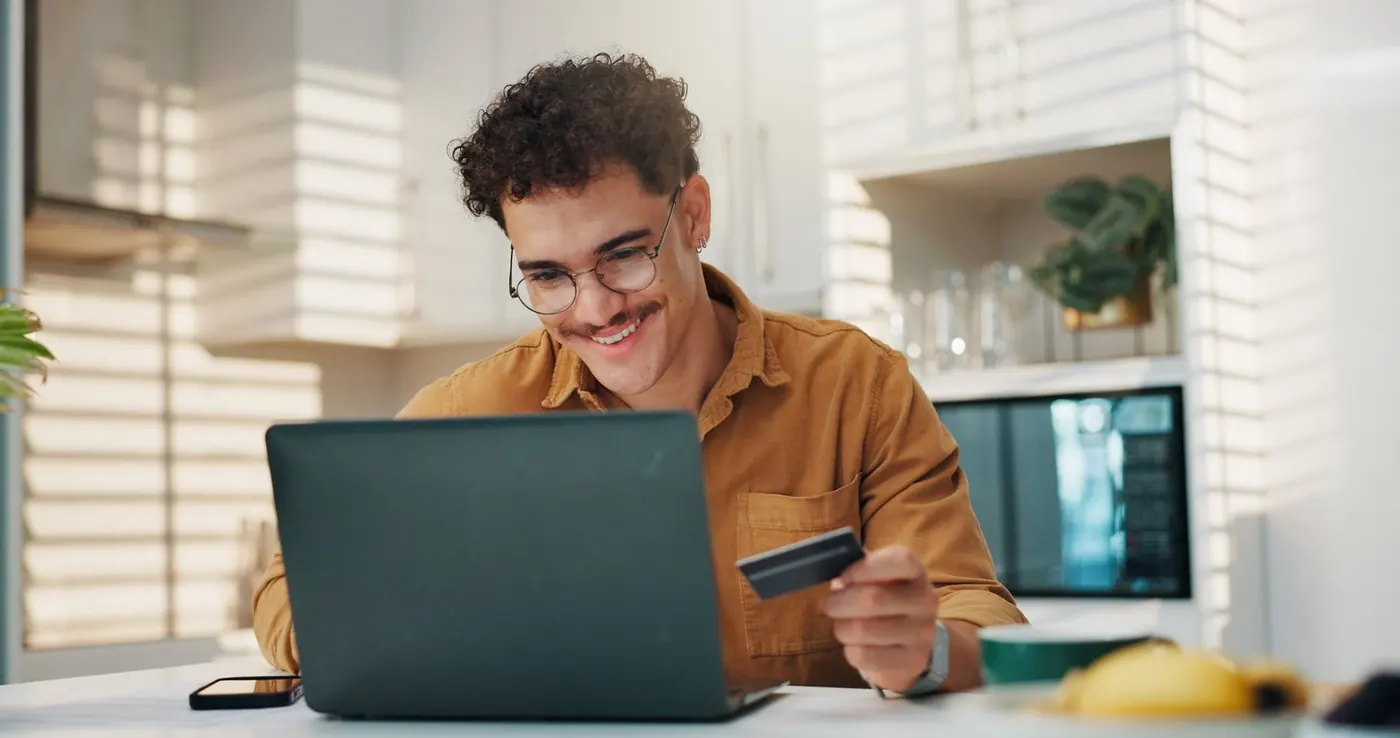 Customer paying online with a card at his laptop